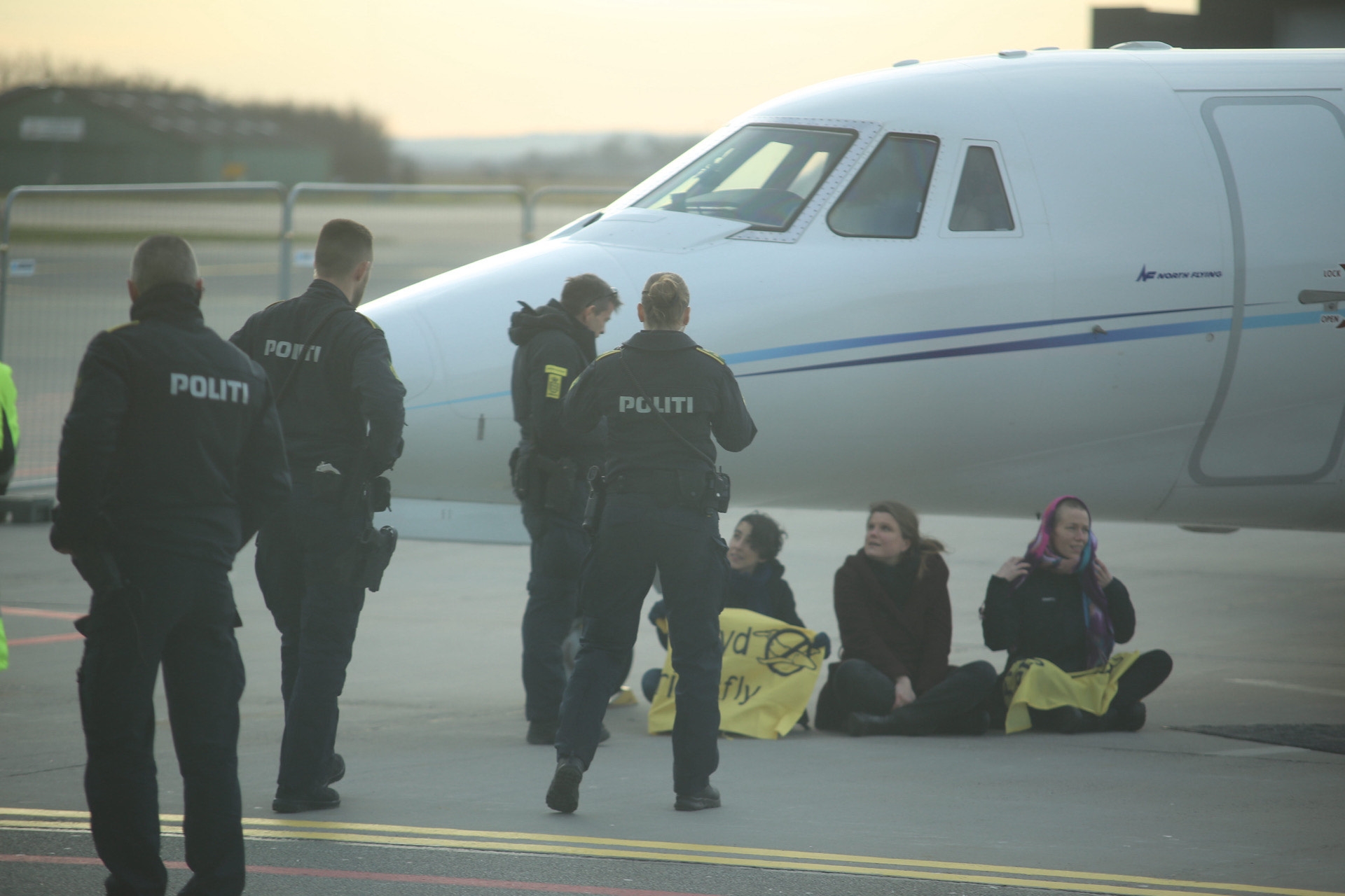 Demonstration Ved Lufthavn: Demonstranter Sætter Sig Foran Flyet