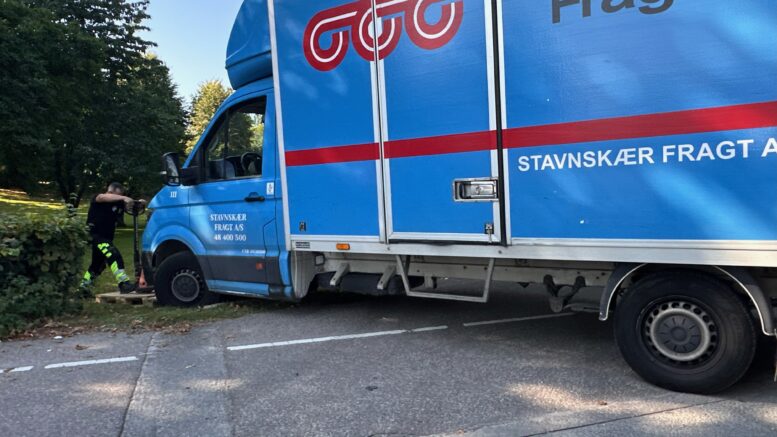 En fragtbil i et uheld skaber trafikale udfordringer, efter det store køretøj har sat sig fast