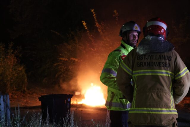 Politiet beskytter brandvæsnet under slukning i boligkvarter