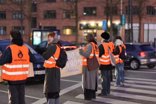 Aktivister blokerer for bilister i trafikeret kryds