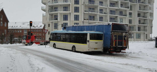 Bus og lastbil glider sammen i kryds