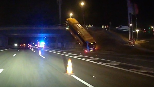 Bus hamrer op på motorvejsbro: Hænger nærmest i luften