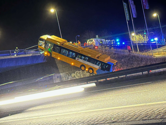 Bus hamrer op på motorvejsbro: Hænger nærmest i luften