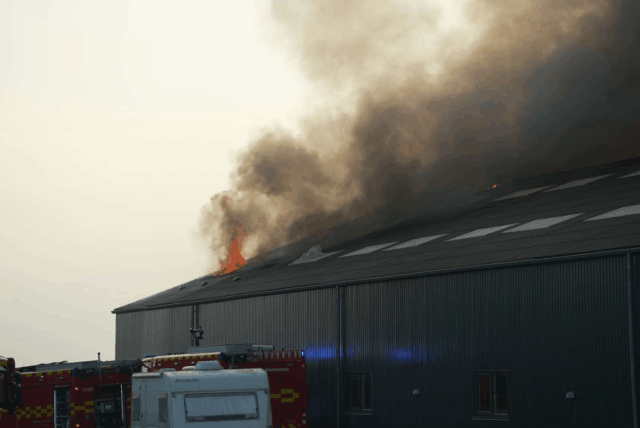 Brandfolk knokler på gård: Flammer og røg vælter ud af tag