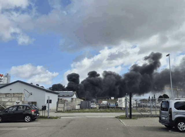 Stor sort røgsky driver over byen
