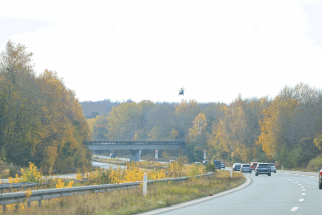 PET-helikopter overflyver motorvej i lav højde: Skud i skovområde