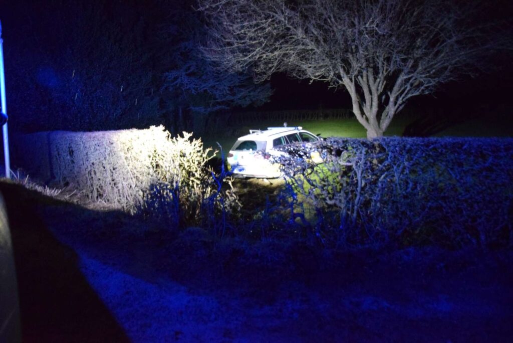 Den stjålene patruljevogn smadrede igennem hækken. 