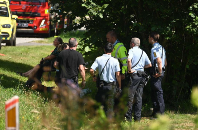 I græsset sidder den ene bilist på en campingstol: På vejen kæmper den anden for livet